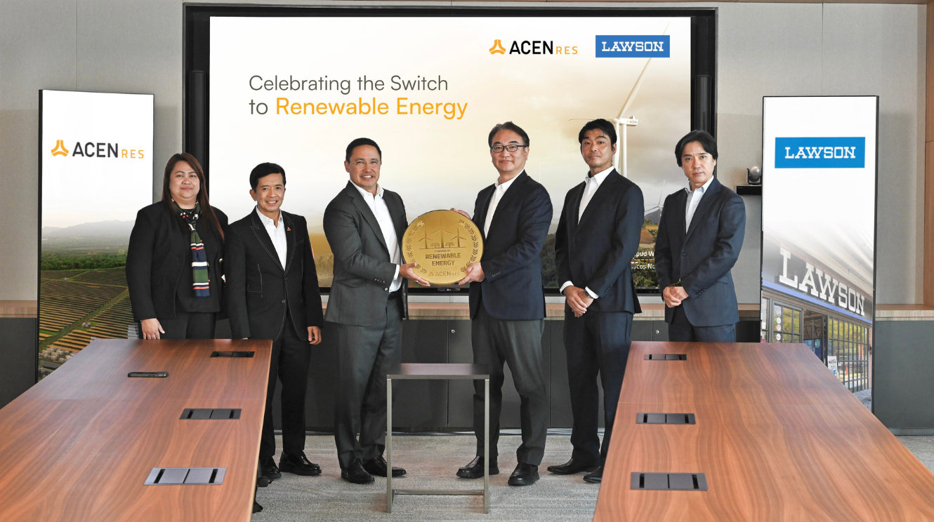 Executives from Lawson Philippines and ACEN RES stand during a contract signing ceremony marking the switch to renewable energy, with company logos and a renewable energy backdrop displayed.